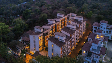 Drone shot of the property amid dense tree cover at dusk at Perfectstayz Premium Carnival Suites, Marra, Goa.