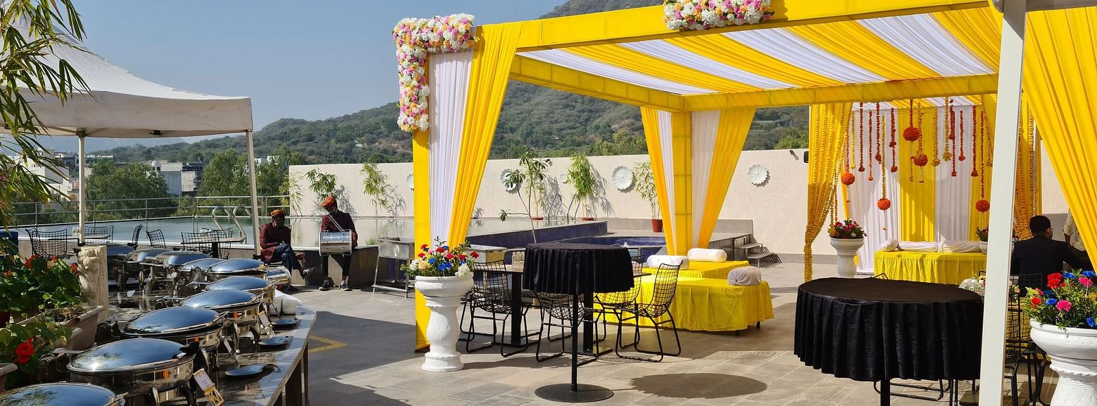 Outdoor tent with tables, mountain view.