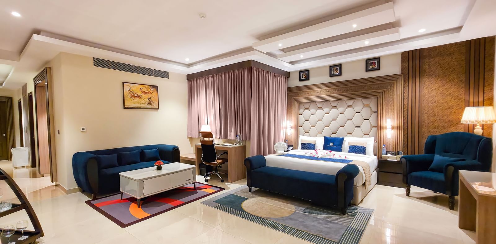 Full view of the Presidential Suite featuring the master bedroom along with a separate seating area in the corner at The Meriton.