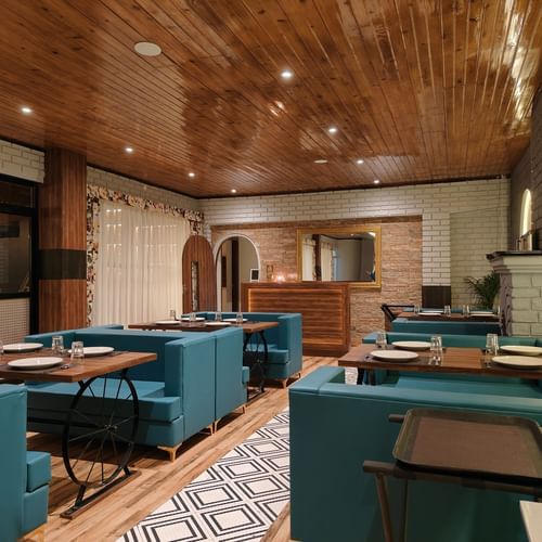 An image of a dining area with sofa chairs and table with wooden furnishings - Mount Polaris Suites & Spa, Kalimpong!