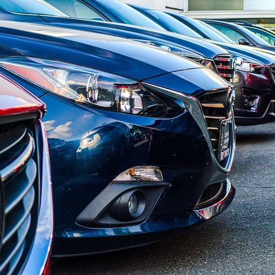 many cars parked next to each other in a parking lot