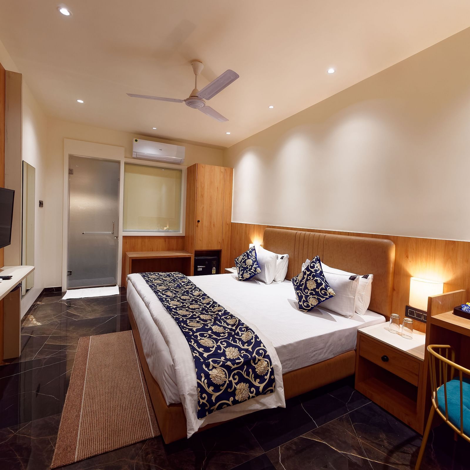 A double bed and a television in a room at M Square Hotels & Resorts