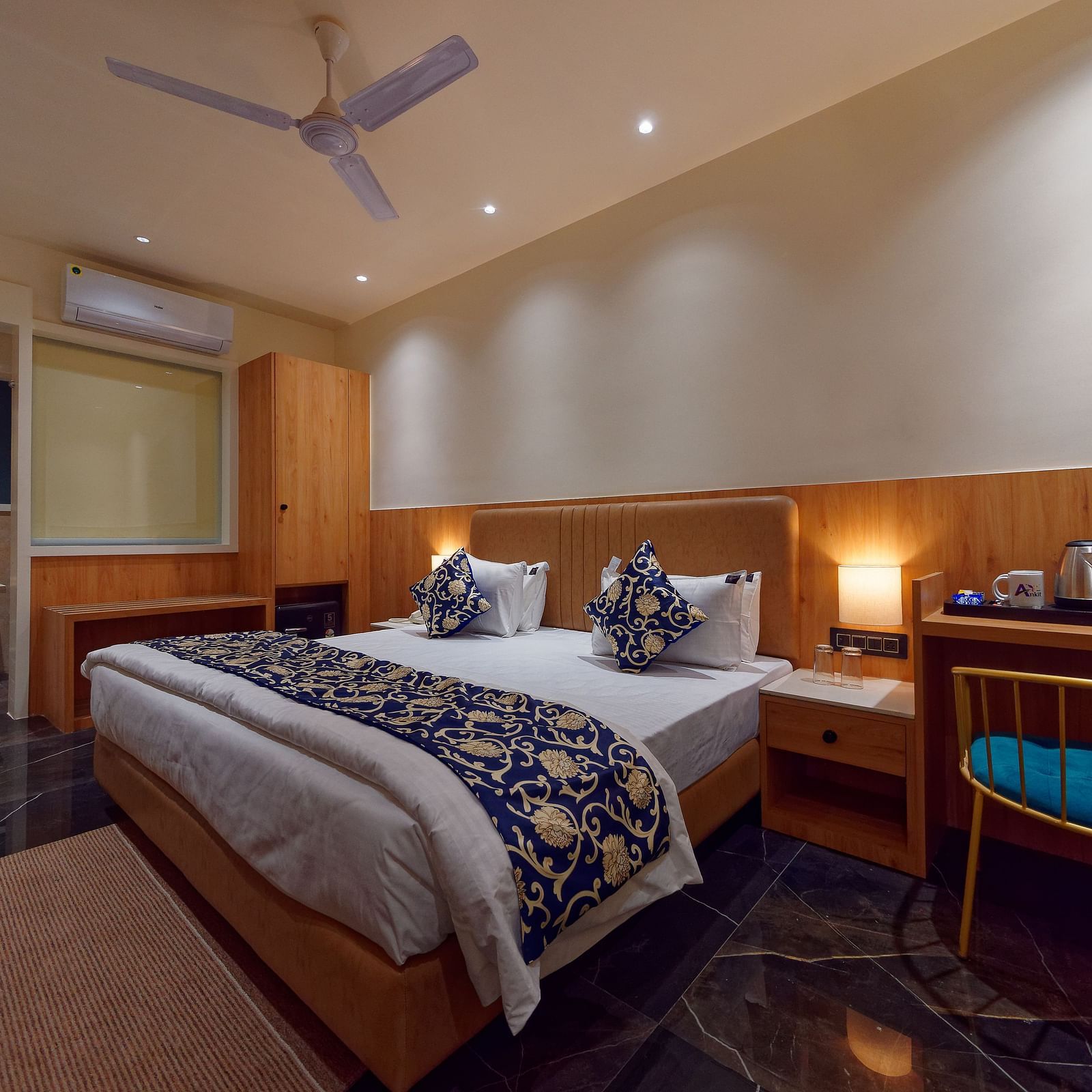 A double bed and a work desk and chair in a room at M Square Hotels & Resorts