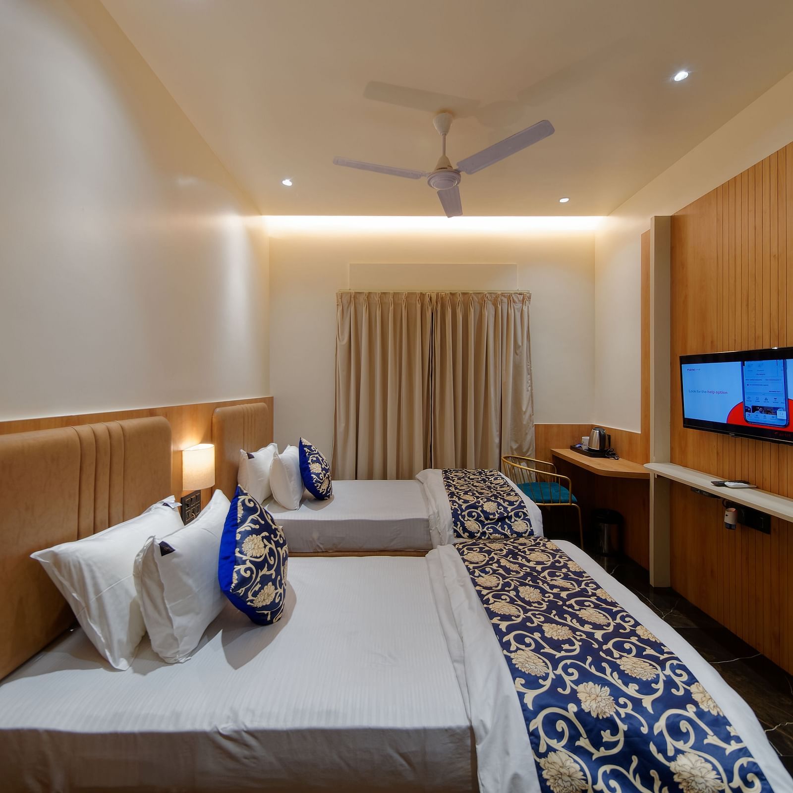 Twin beds and a television in a room at M Square Hotels & Resorts