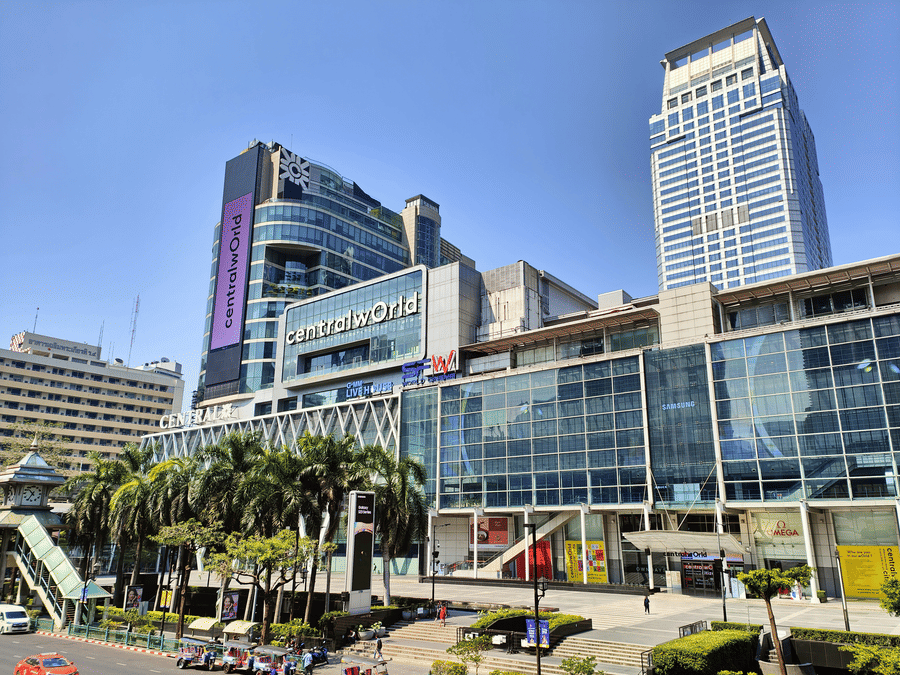 A view of the facade of CentralWorld in Bangkok during the day with buggy's parked in front of it.