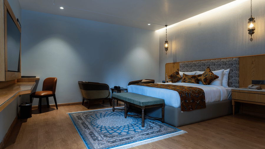 Spacious bedroom at Mountnoor Sarovar Premiere, Pahalgam designed with elegant furnishings and warm lighting.