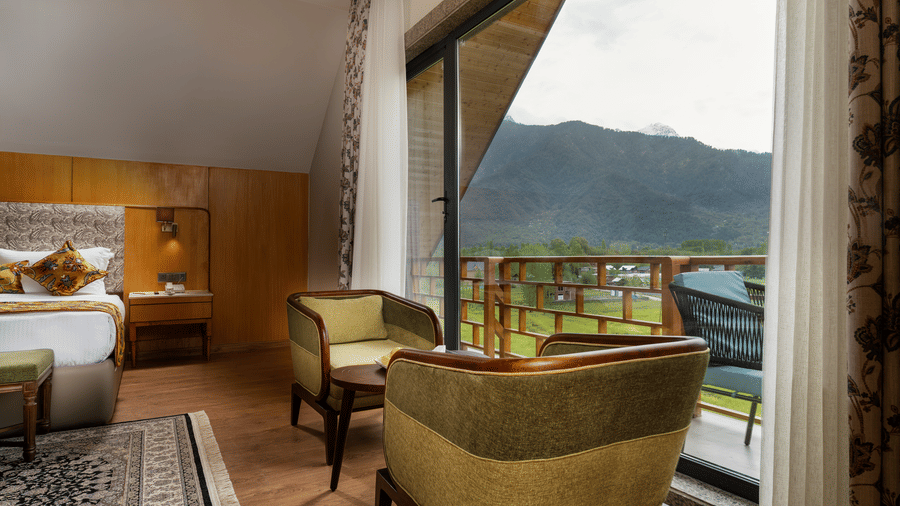 Cosy seating area in a premium room at Mountnoor Sarovar Premiere, Pahalgam overlooking scenic valleys.