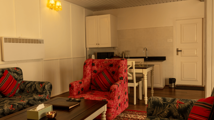 A room at The Heritage Club, Tripura, Castle, Shillong, featuring chairs, a table, and doors.