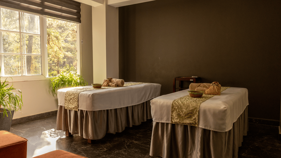 Wellness space at Heritage Club, with a twin beds, pillows, and windows.
