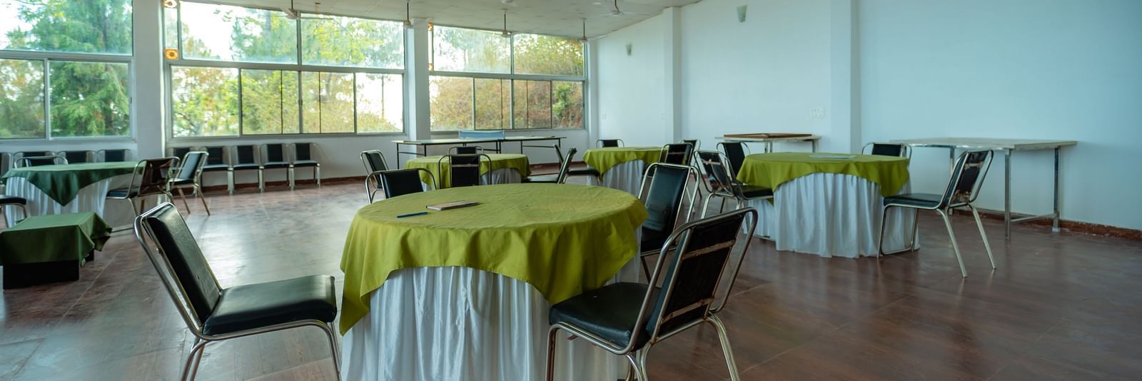 tables and chairs placed in the event venue at Flutter Hotels & Resorts surrounded by beautiful view of the valleys