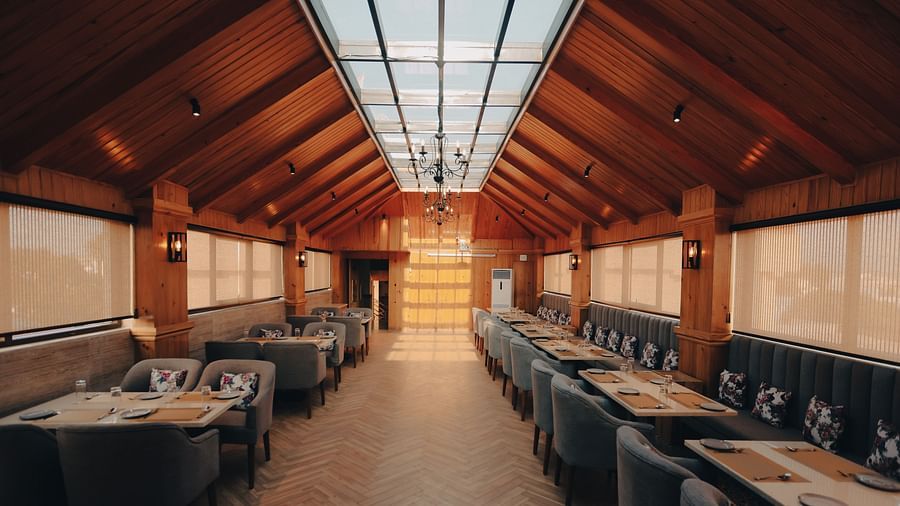 Clarks Inn Express Dehradun - interior view of the Clarks cafe featuring numerous seating options and translucent screens on either sides
