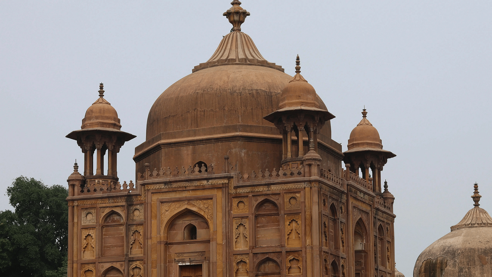 A large, ornate tomb or historical building with a prominent dome and intricate architectural details.