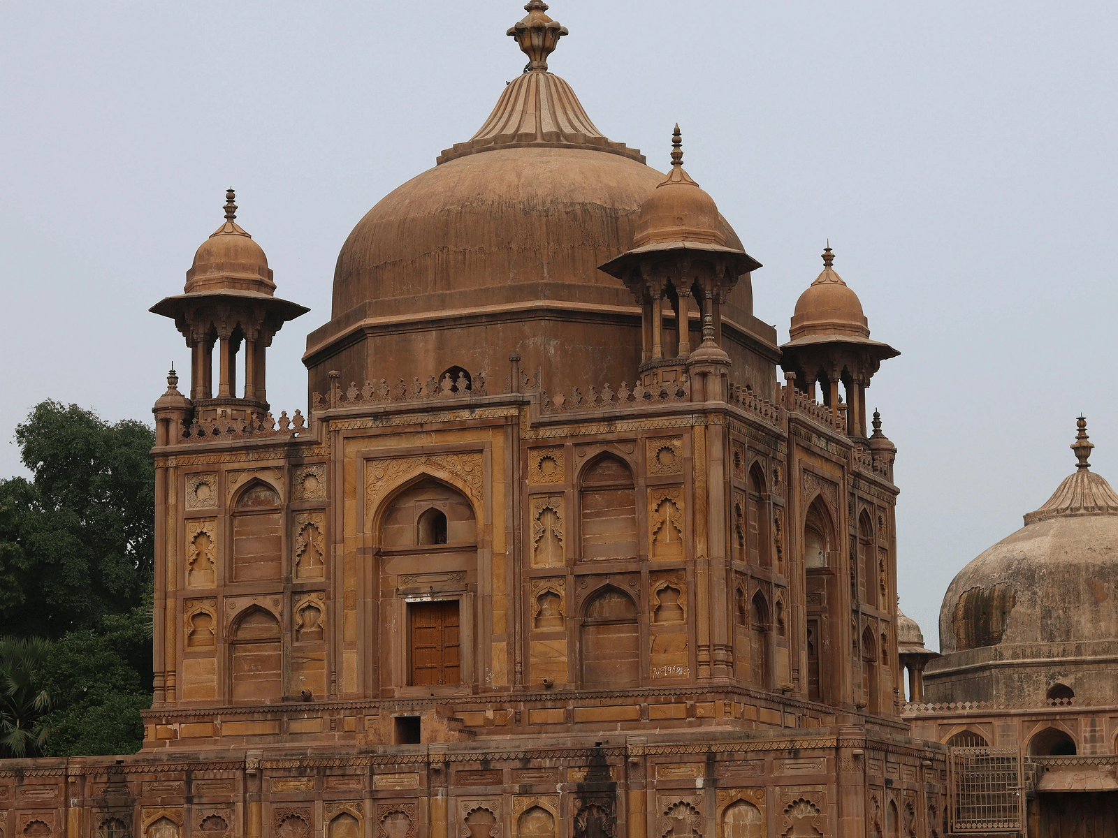 A large, ornate tomb or historical building with a prominent dome and intricate architectural details.