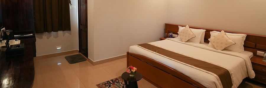 a bedroom with a large double bed - MGM Whispering Wind's, Yelagiri