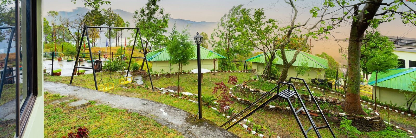 a view of a garden featuring a slide and a swing at Flutter Hotels & Resorts