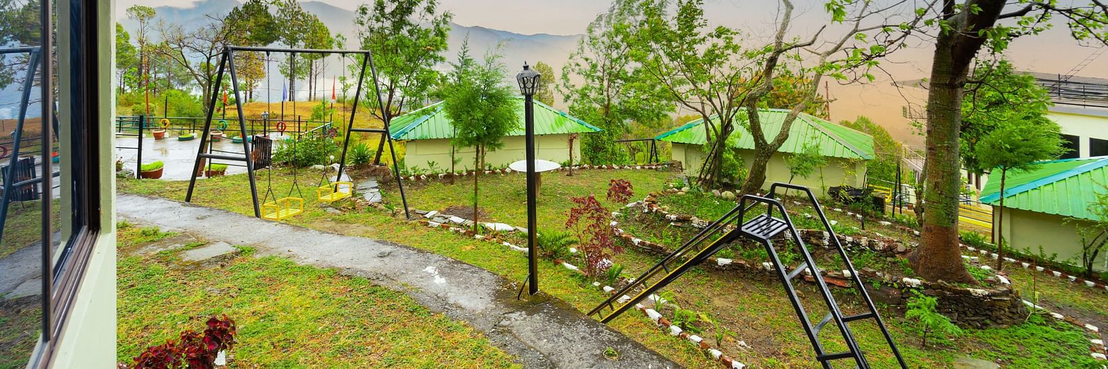 a view of a garden featuring a slide and a swing at Flutter Hotels & Resorts
