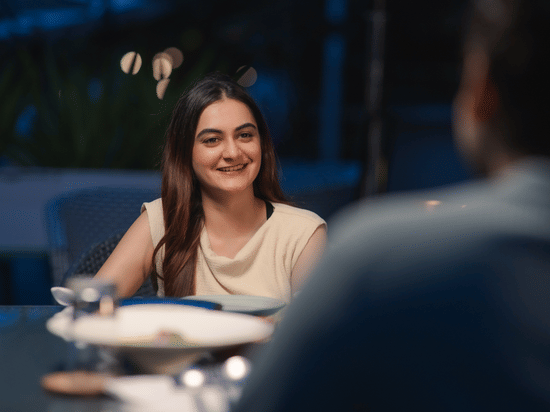 A woman sitting with a smiling face infront of a man. | Karma Lakelands