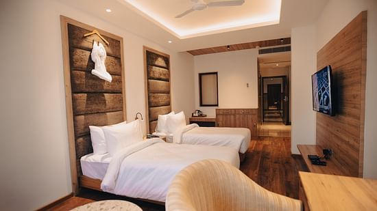 Clarks Inn Express Dehradun - interior view of the deluxe room featuring twin beds ceiling fan a television and a work desk