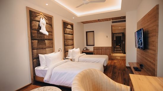 Clarks Inn Express Dehradun - interior view of the deluxe room featuring twin beds ceiling fan a television and a work desk