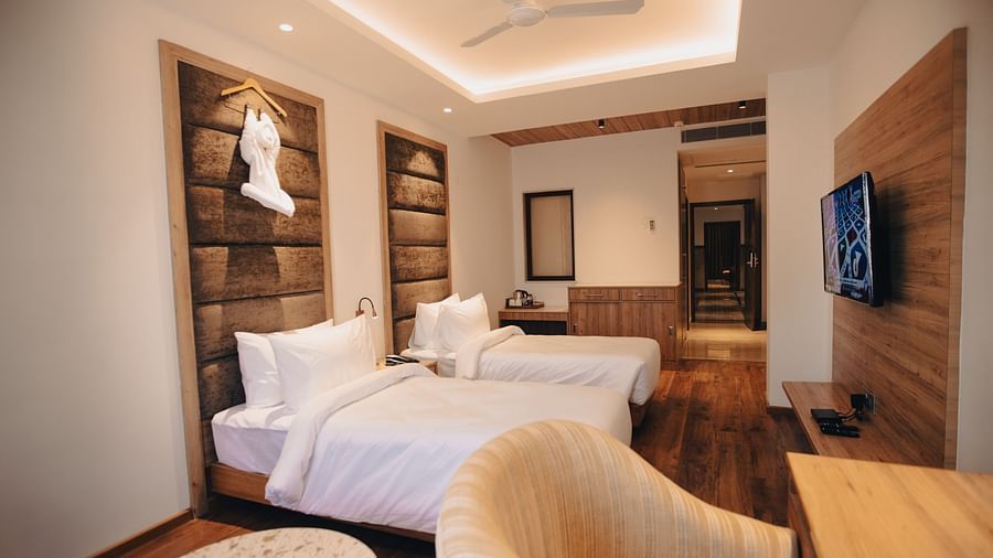 Clarks Inn Express Dehradun - interior view of the deluxe room featuring twin beds ceiling fan a television and a work desk