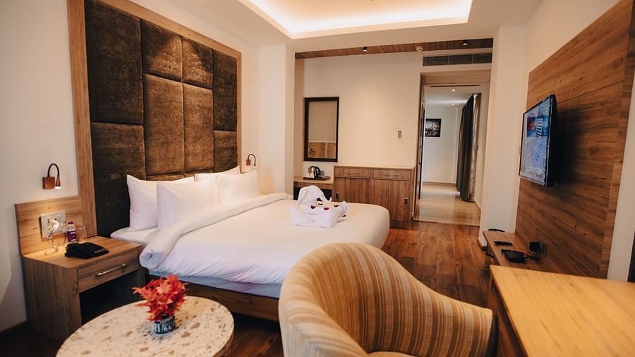 Clarks Inn Express Dehradun - interior view of the executive room featuring a king size bed a work table and a television in yellow lighting