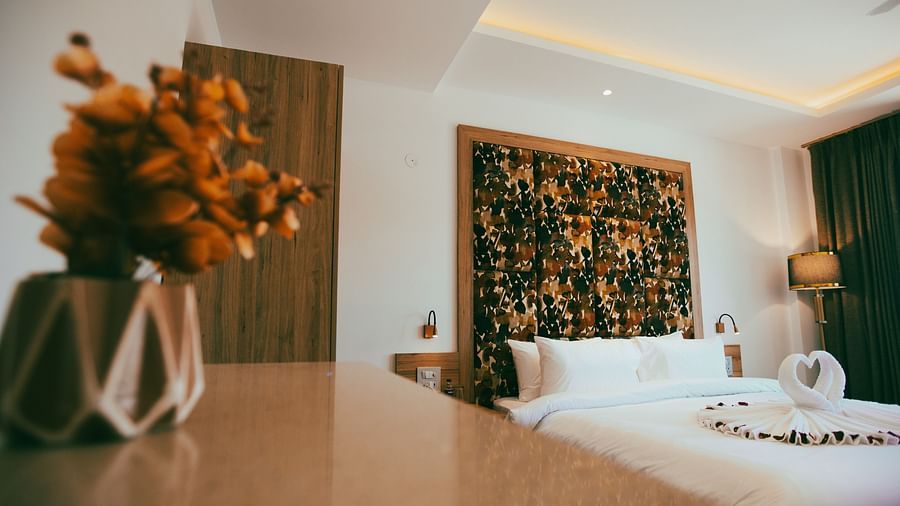 Clarks Inn Express Dehradun - interior view of the suite featuring a king size bed towel decorations a lamp and vase