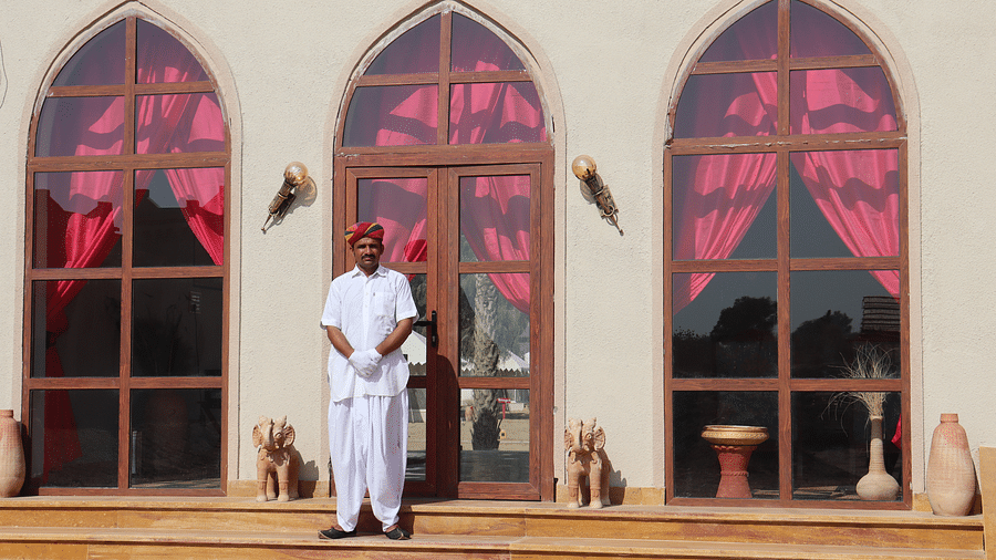 A hotel staff stands next to the three archways - Karwaan Jaisalmer