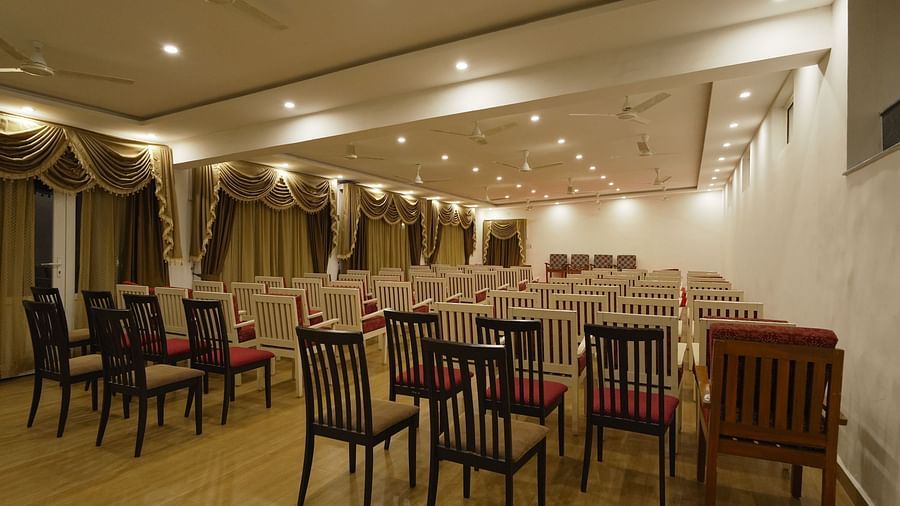 Interior image of a hall with the chairs arranged in it, and wel lit.