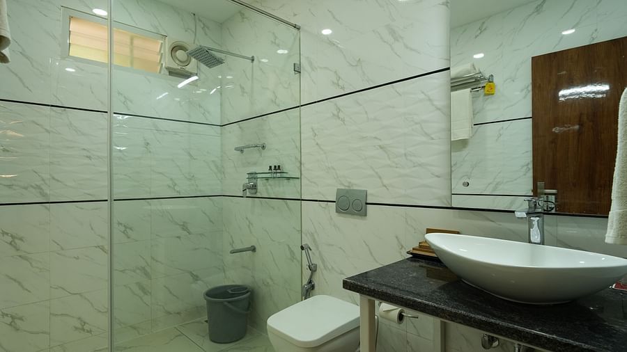 A clean and modern bathroom with a shower, sink, and toilet - MGM Whispering Wind's Resorts