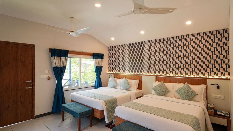 A spacious and well-lit bedroom with comfortable beds and stylish decor - MGM Whispering Wind's Resorts