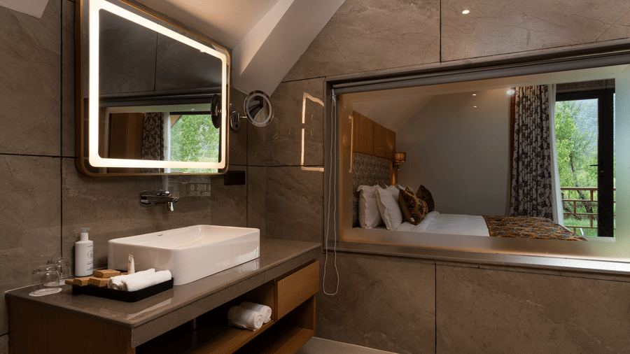 Modern bathroom at Mountnoor Sarovar Premiere, Pahalgam featuring a stylish bathtub and elegant lighting.