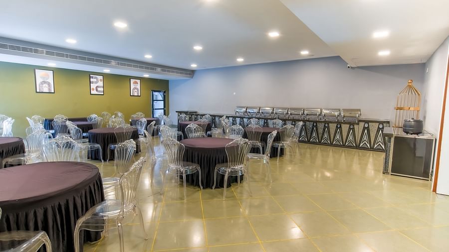 Interior of Royal Affair at Darza Resort features round tables with dark tablecloths and clear chairs, along with buffet serving stations.