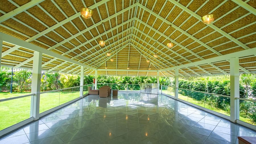 Slice of Heaven at Darza Resort featuring a spacious covered outdoor area with a high bamboo and white frame roof, polished floor, and open sides overlooking lush greenery.