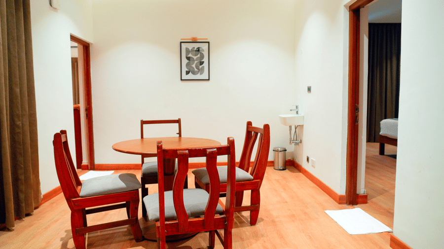 A room with a table and chairs placed near a doorway at DNC Shevaroys Resorts and Spa.