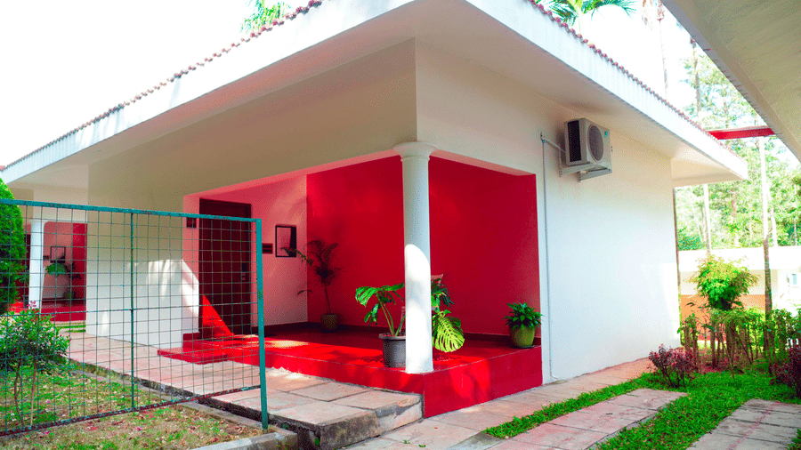 A villa exterior with a pathway, a fence, and plants at DNC Shevaroys Resorts and Spa.