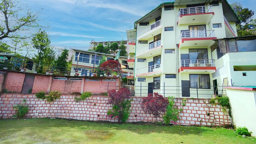 Facade of Flutter Hotels and Resorts with a brick wall separating a lawn.