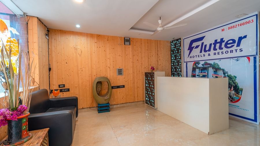 Reception desk at Flutter Hotels and Resorts, Lansdowne with a sofa and wooden decors.
