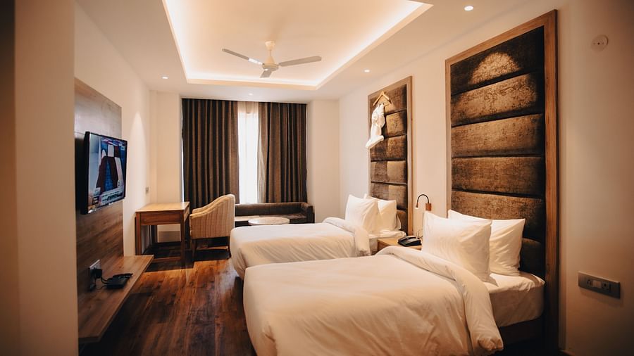 Clarks Inn Express Dehradun - interior view of the deluxe room featuring twin beds brown decor and yellow lighting