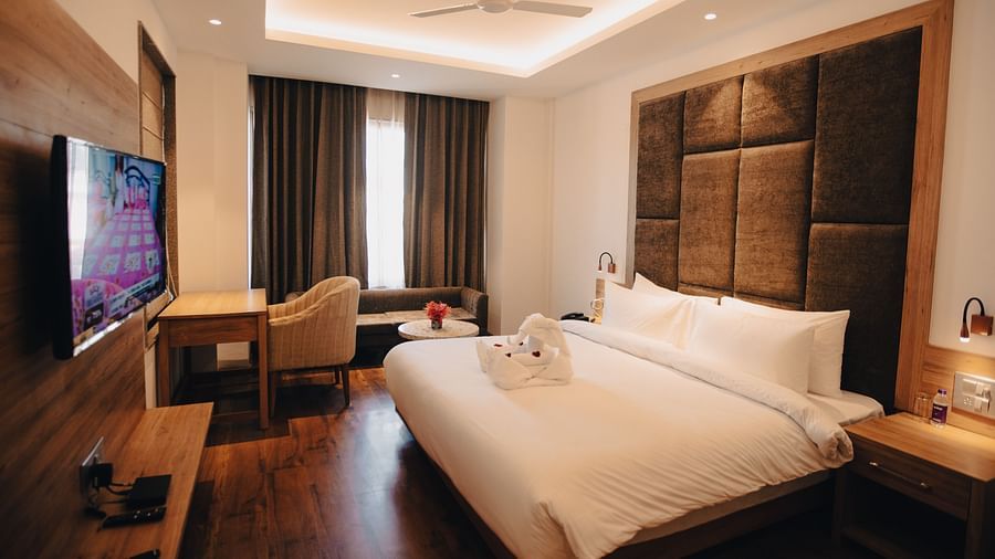 Clarks Inn Express Dehradun - interior view of the executive room featuring a king size bed wooden flooring and a television