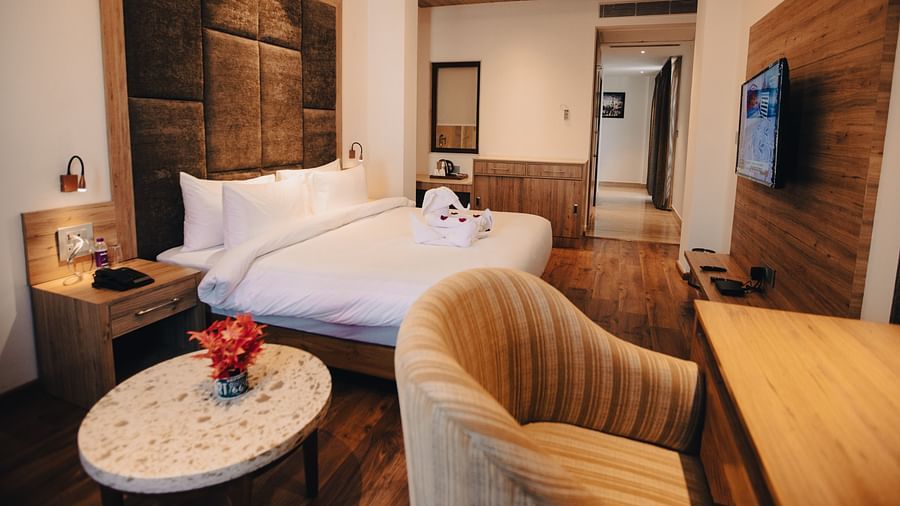 Clarks Inn Express Dehradun - interior view of the executive room featuring a king size bed a work table and a television in yellow lighting