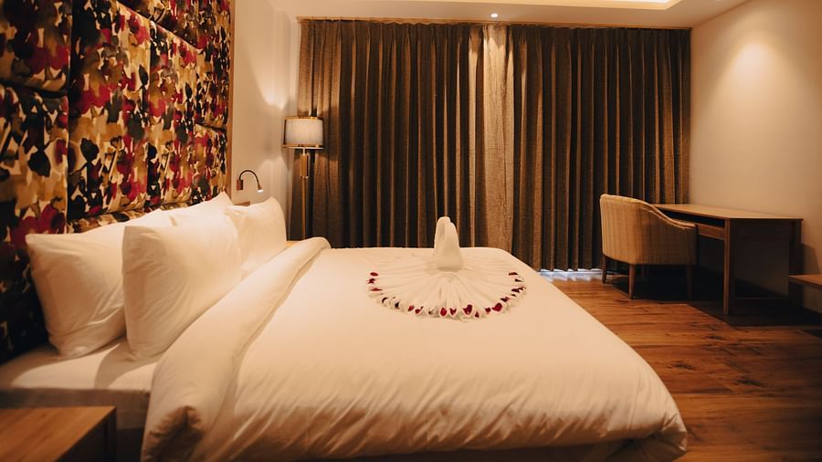 Clarks Inn Express Dehradun - interior view of the suite featuring a king size bed and a work table in yellow lighting