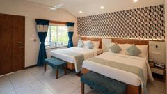 A spacious and well-lit room with comfortable beds and modern decor - MGM Whispering Wind's Resorts