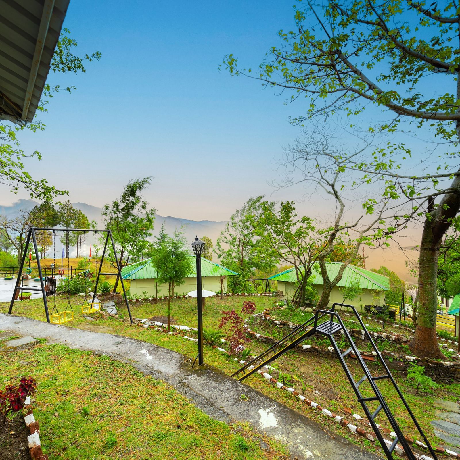 a view of a garden featuring a slide and a swing at Flutter Hotels & Resorts
