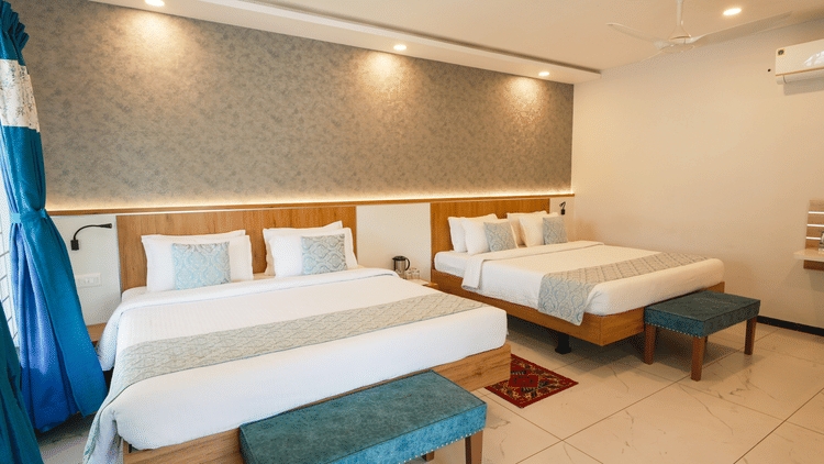 A spacious and well-lit room with comfortable beds and modern decor - MGM Whispering Wind's Resorts