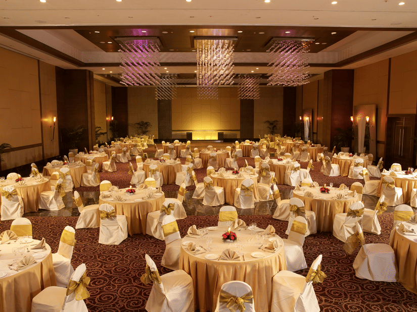 A banquet hall with round linen-covered tables set for a formal event at The Retreat Hotel and Convention Centre.
