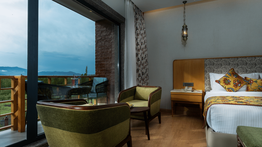 Elegant room at Mountnoor Sarovar Premiere, Pahalgam with cosy seating and panoramic mountain views.