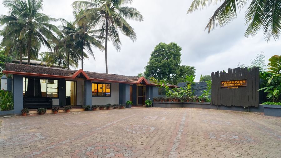 Facade of Parampara Resort & Spa, Coorg, Kushalnagar with trees surrounding it.