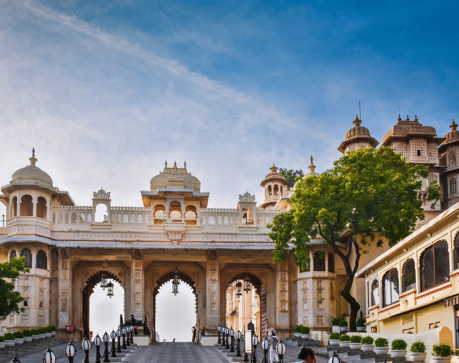 View of City Palace, Udaipur, with its arched gateways and domes under a the sky.