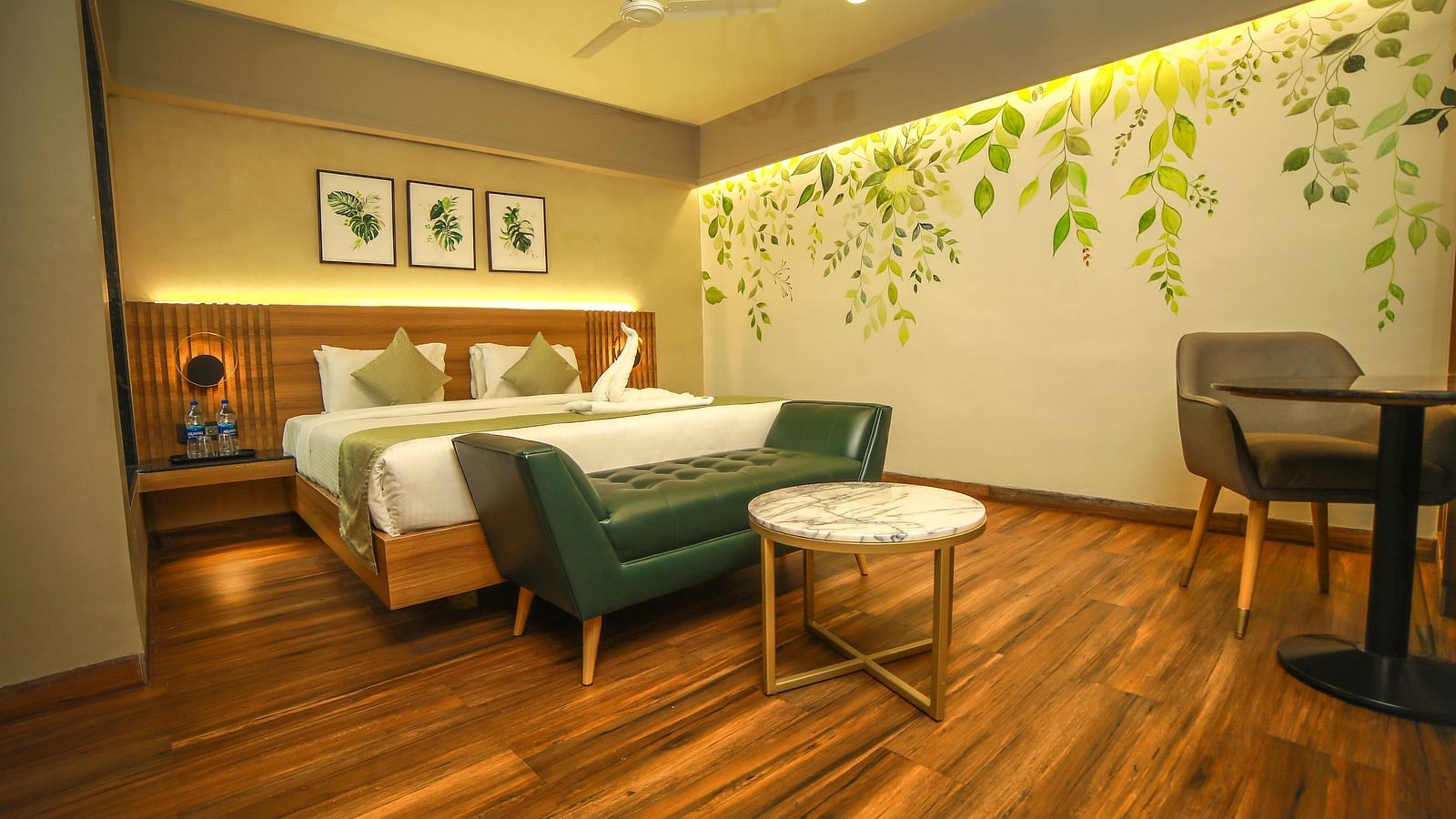 Wide view of a bed and a couch in front of in the Standard Room at Grand Palace, Yercaud