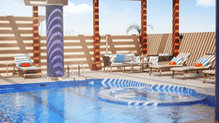 an overview of a swimming pool with loungers on the side - La Maison Hotel, Doha